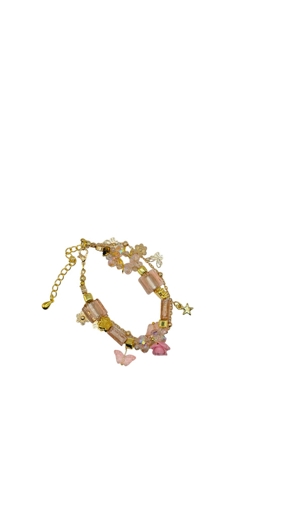 Bracelet with pink beads and gold chain on a white circular card