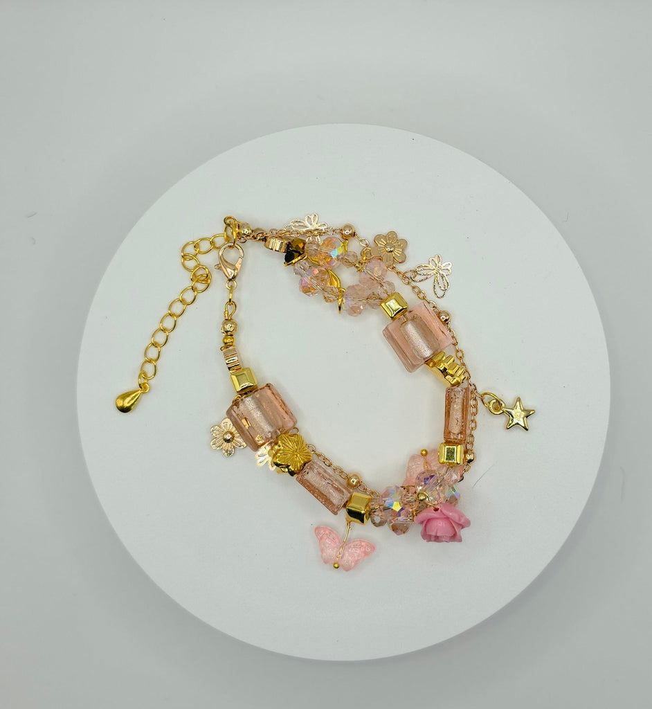 Bracelet with pink beads and gold chain on a white circular card